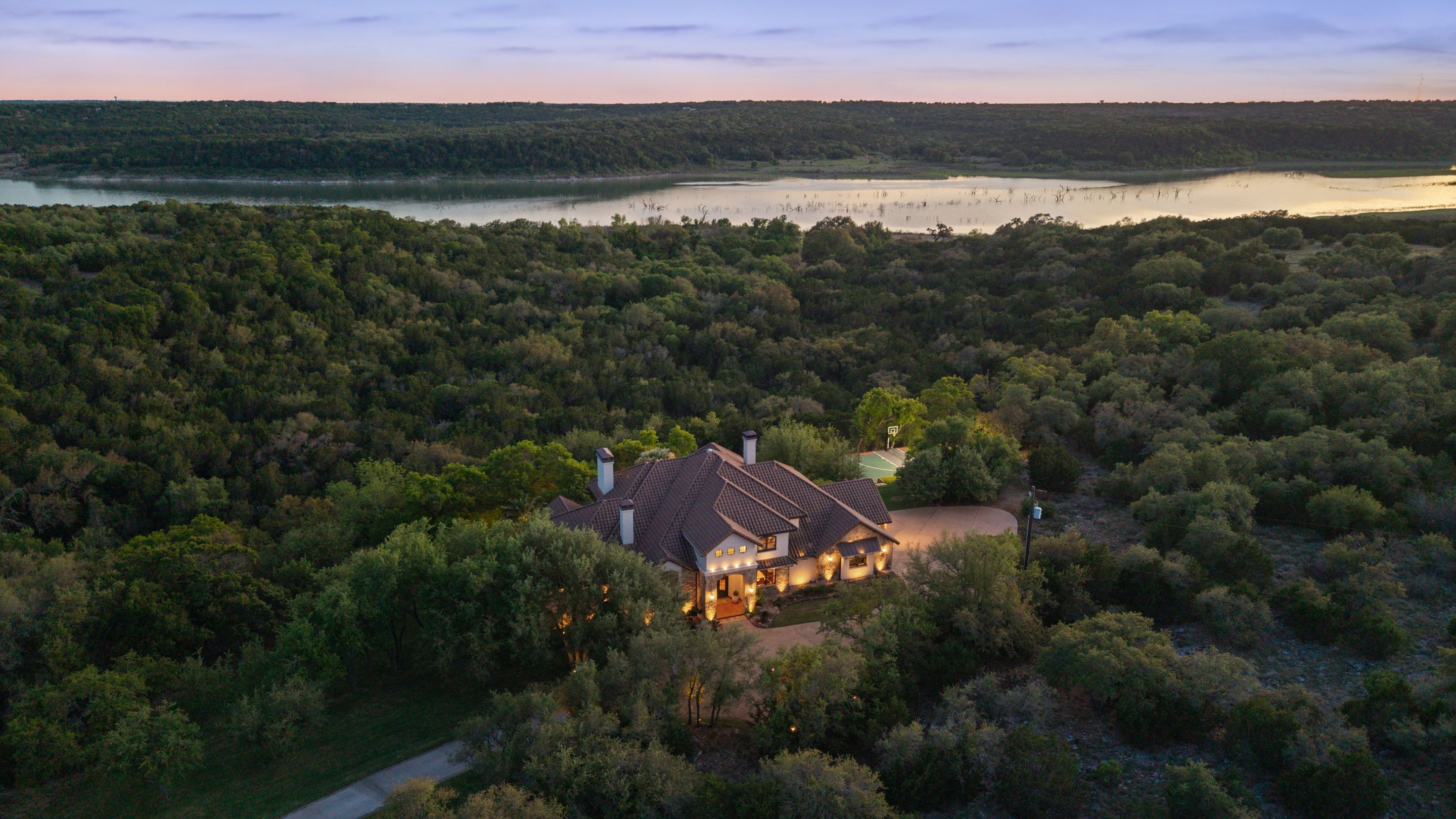 Lakehaven aerial at dusk with the lake beyond the residence